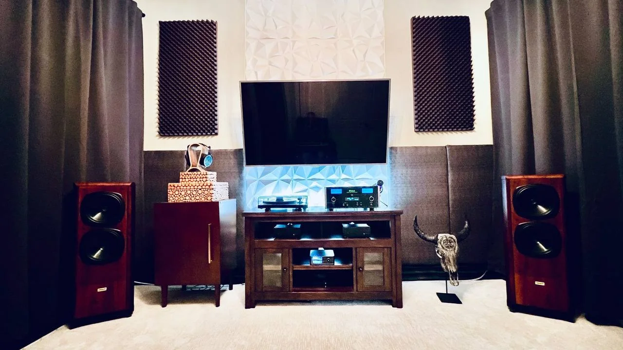 Jeremy’s home listening room with two wood-finish floorstanding speakers flanking a central equipment cabinet.